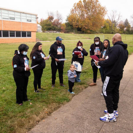 Cory Long talking to kids outside gathered in a circle
