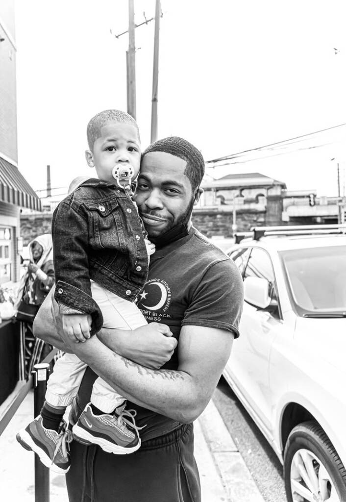 Kharon Randolph holds up a young child