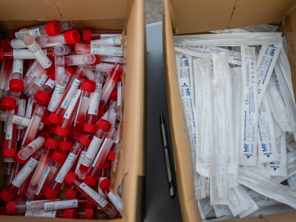 Vials of testing fluid and packages of nose swabs are seen at a drive through COVID-19 testing site