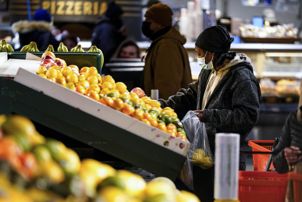Virus Outbreak Pennsylvania A shopper wearing a face mask selects fruit at the Reading Terminal Market