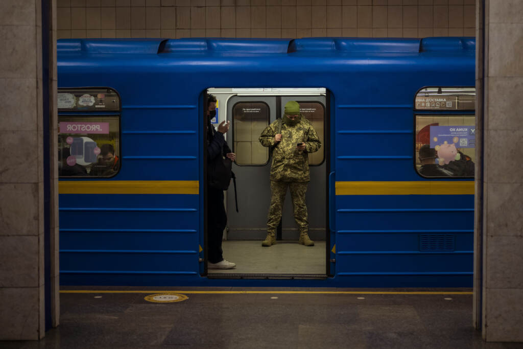 A Ukrainian army officer looks at his phone in a local train