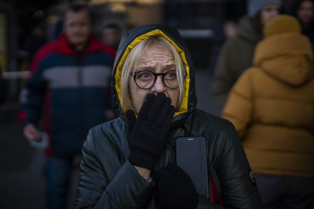A woman reacts to sirens sound announcing new attacks in Kyiv