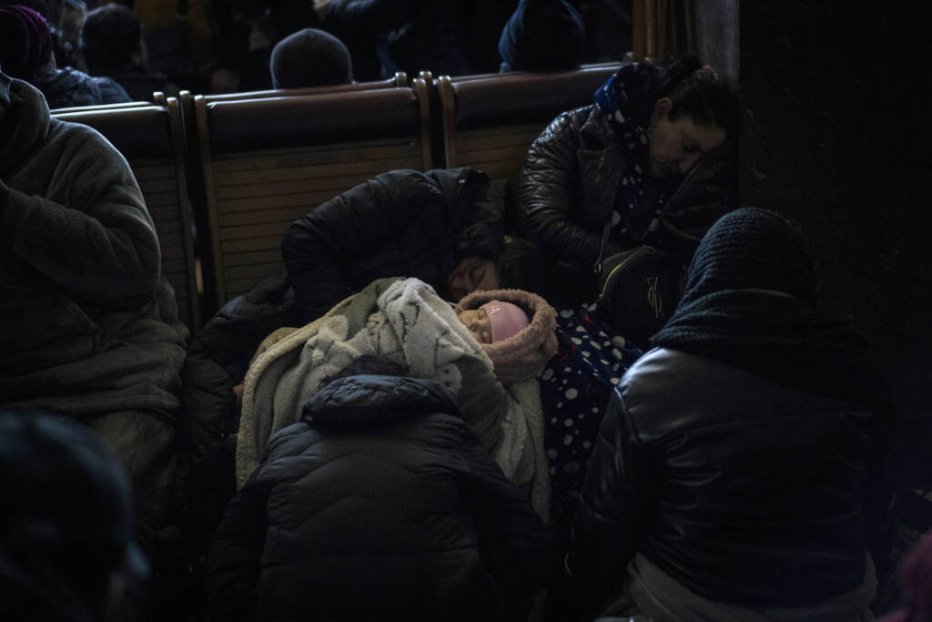 A baby is seen sleeping inside Lviv railway station