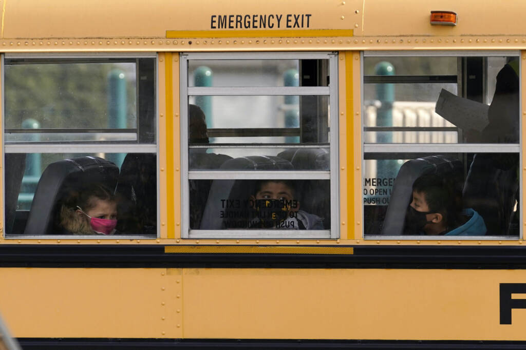 Virus Outbreak Reopening Schools Elementary school students are pictured on a school bus