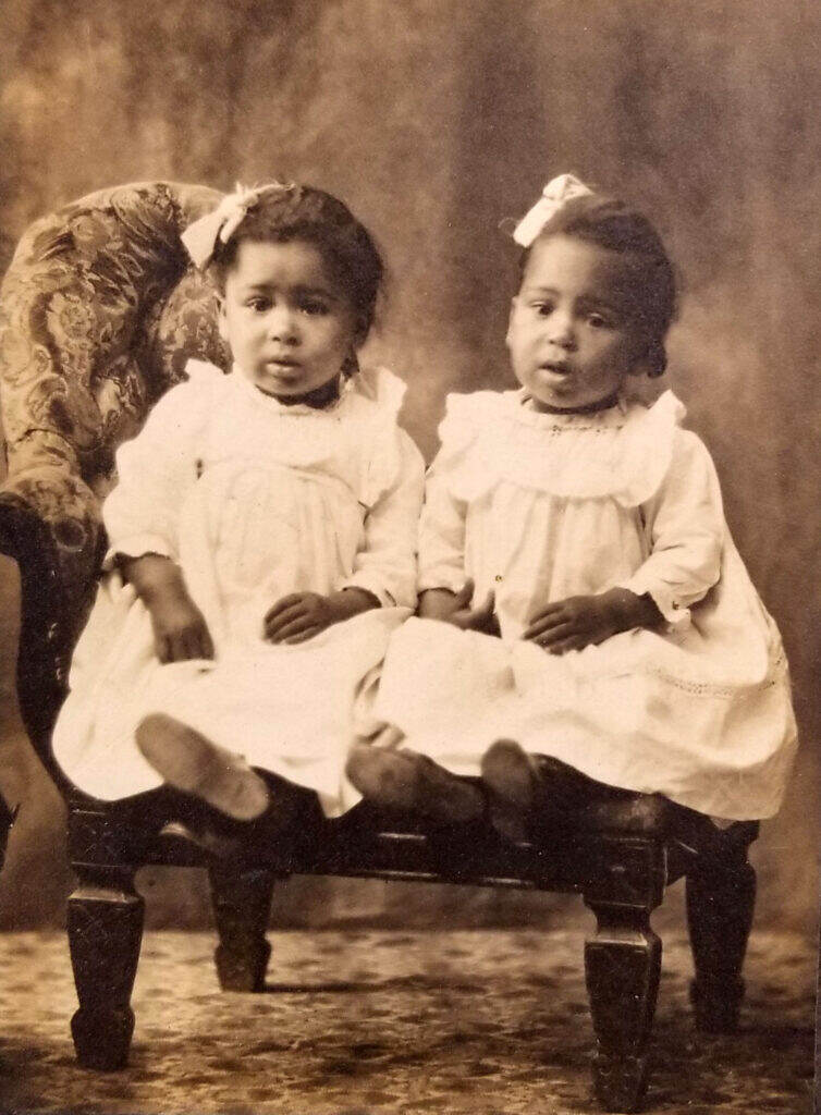 A photo of twin girls dressed up in their finest