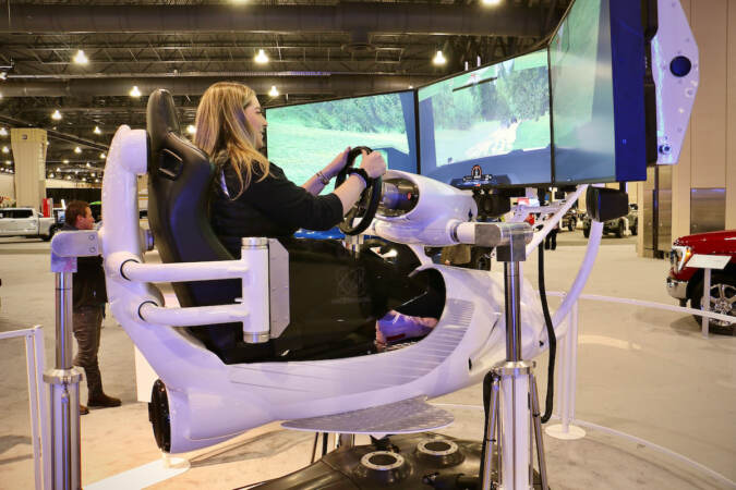 Dari Shore of Philadelphia tries out the performance simulator at the Philadelphia Auto Show. (Emma Lee/WHYY)