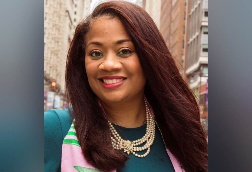 Gail Carter-Hamilton smiles, wearing a pink and green scarf and necklace.