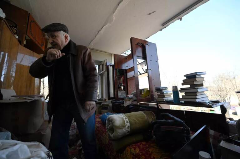 A local resident collects the belongings out of his apartment in Kyiv on Sunday in a five-story residential building that partially collapsed after a shelling by Russian troops. (Sergei Supinsky/AFP via Getty Images)