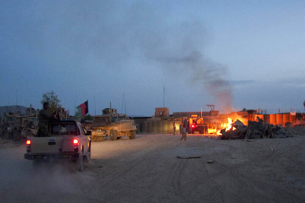 Congress Veterans Burn Pits In this April 28, 2011, photo, an Afghan National Army pickup truck passes parked U.S. armored military vehicles, as smoke rises from a fire in a trash burn pit at Forward Operating Base Caferetta Nawzad, Helmand province south of Kabul, Afghanistan. The House just passed legislation that may dramatically boost health care services and disability benefits for veterans exposed to burn pits in Iraq and Afghanistan. (AP Photo/Simon Klingert, File)
