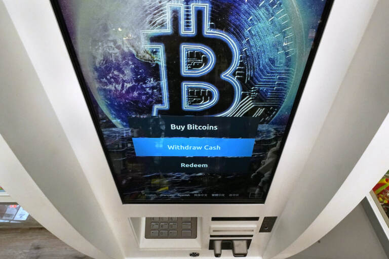 A Bitcoin logo appears on the display screen of a cryptocurrency ATM at the Smoker's Choice store in Salem, N.H. President Joe Biden is signing an executive order on government oversight of cryptocurrency that urges the Federal Reserve to explore whether the central bank should create its own digital currency