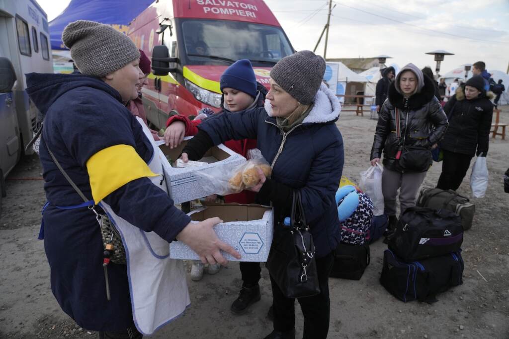 Moldova Russia Ukraine War A Moldovan volunteer distributes food to refugees who are leaving to Romania after fleeing from Ukraine, at the border crossing in Palanca, Moldova, Thursday, March 17, 2022