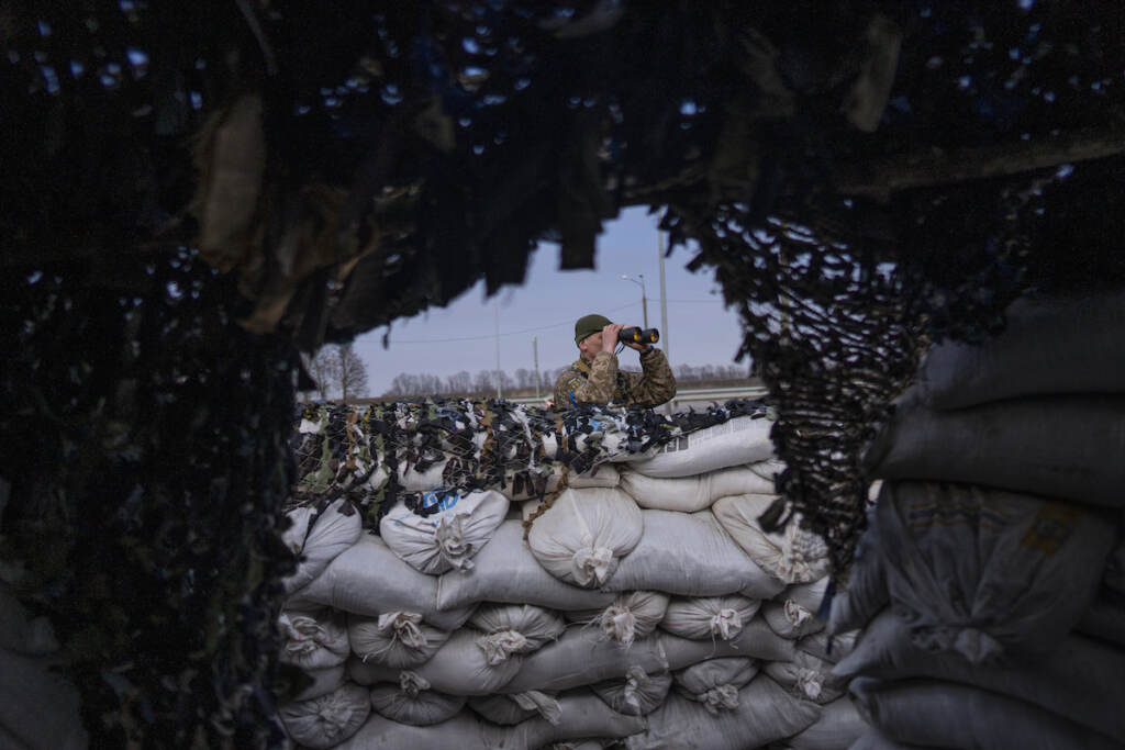 Russia Ukraine War So Far File photo: A Ukrainian soldier looks through binoculars at a military check point, in Lityn, Ukraine, March 16, 2022. (AP Photo/Rodrigo Abd, File)