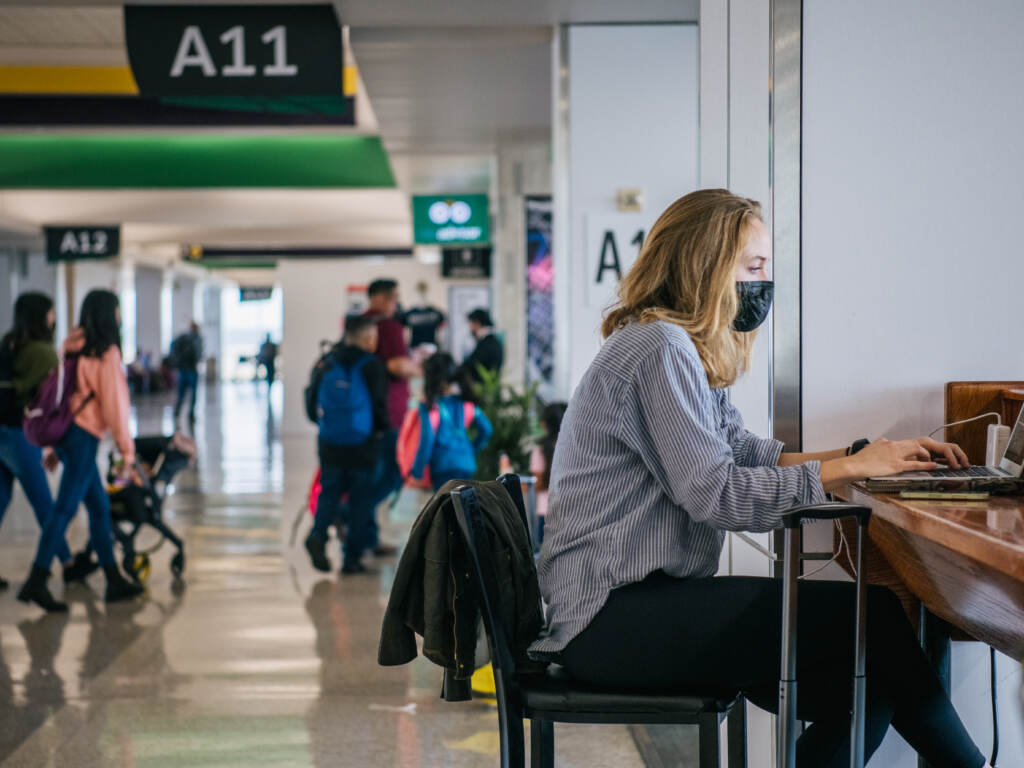 The CEOs of the major U.S. airlines have called on President Biden to end the federal mask mandate for public transportation. Here, a traveler works on a laptop computer at George Bush Intercontinental Airport in Houston on Dec. 3. A person works on their laptop at George Bush Intercontinental Airport on December 03, 2021 in Houston, Texas. (Photo by Brandon Bell/Getty Images)