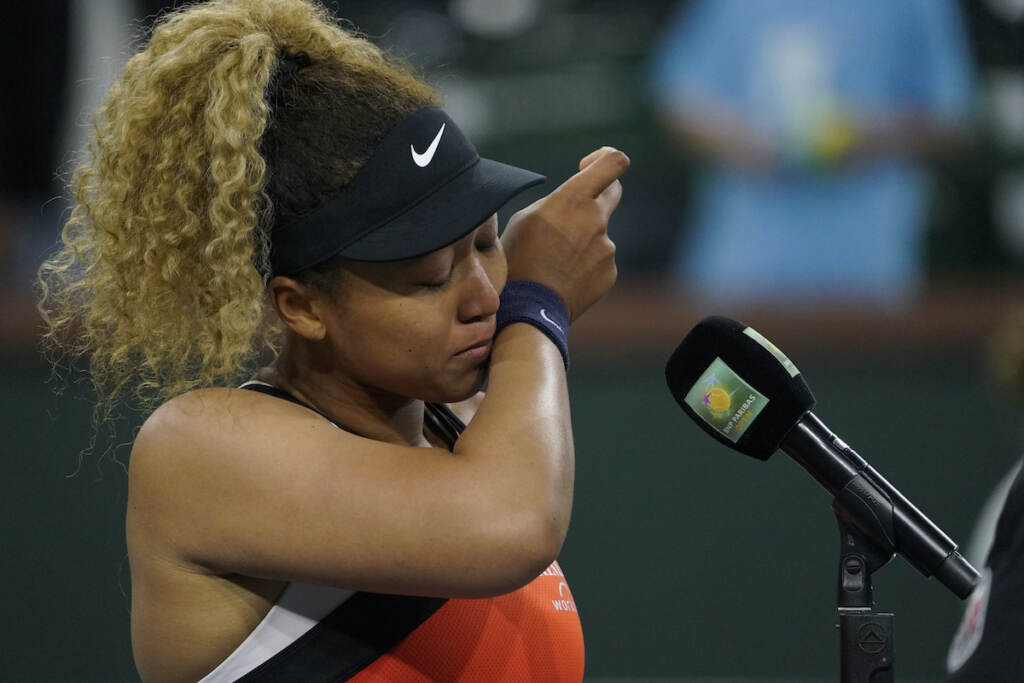 Indian Wells Tennis Tennis star Naomi Osaka appears to wipe tears from her face as she stands in front of a microphone.