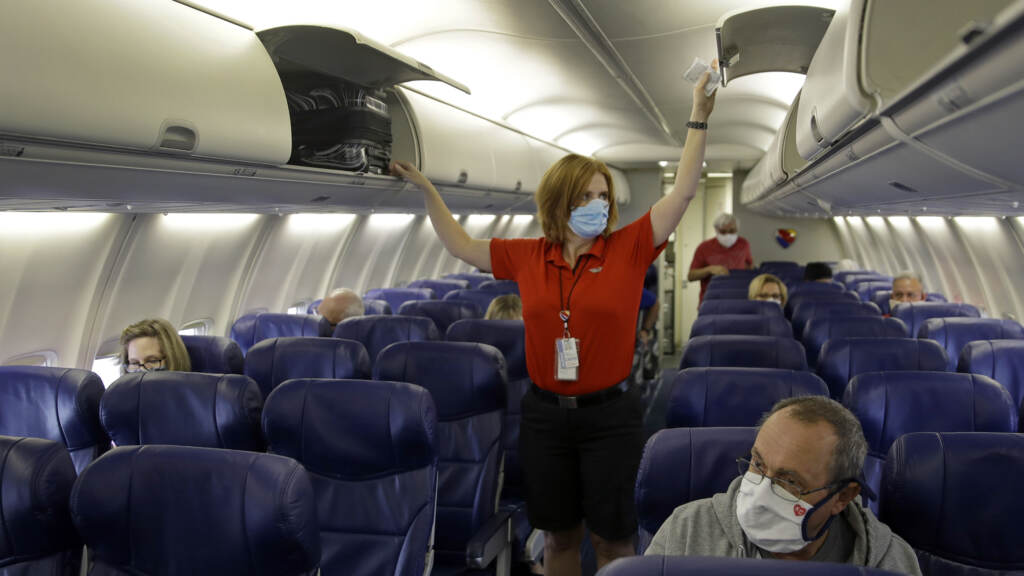 In this 2020 file photo, a Southwest Airlines flight attendant prepares a plane bound for takeoff at the Kansas City International airport in Kansas City, Mo. In this 2020 file photo, a Southwest Airlines flight attendant prepares a plane bound for takeoff at the Kansas City International airport in Kansas City, Mo. (Charlie Riedel/AP)