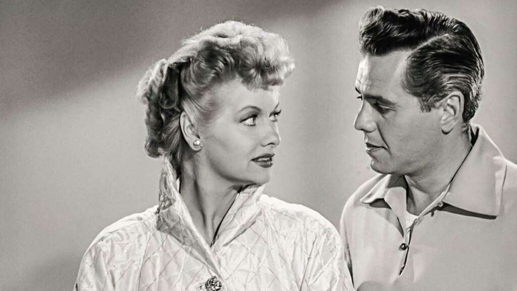 Black and white image of Lucille Ball and Desi Arnaz looking at each other