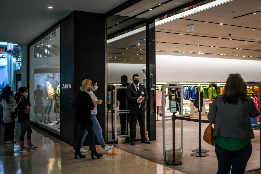 Customers queue to enter a re-opened Zara clothes shop at Colombo shopping center in Lisbon, Portugal, on in April 2021. Customers queue to enter a re-opened Zara