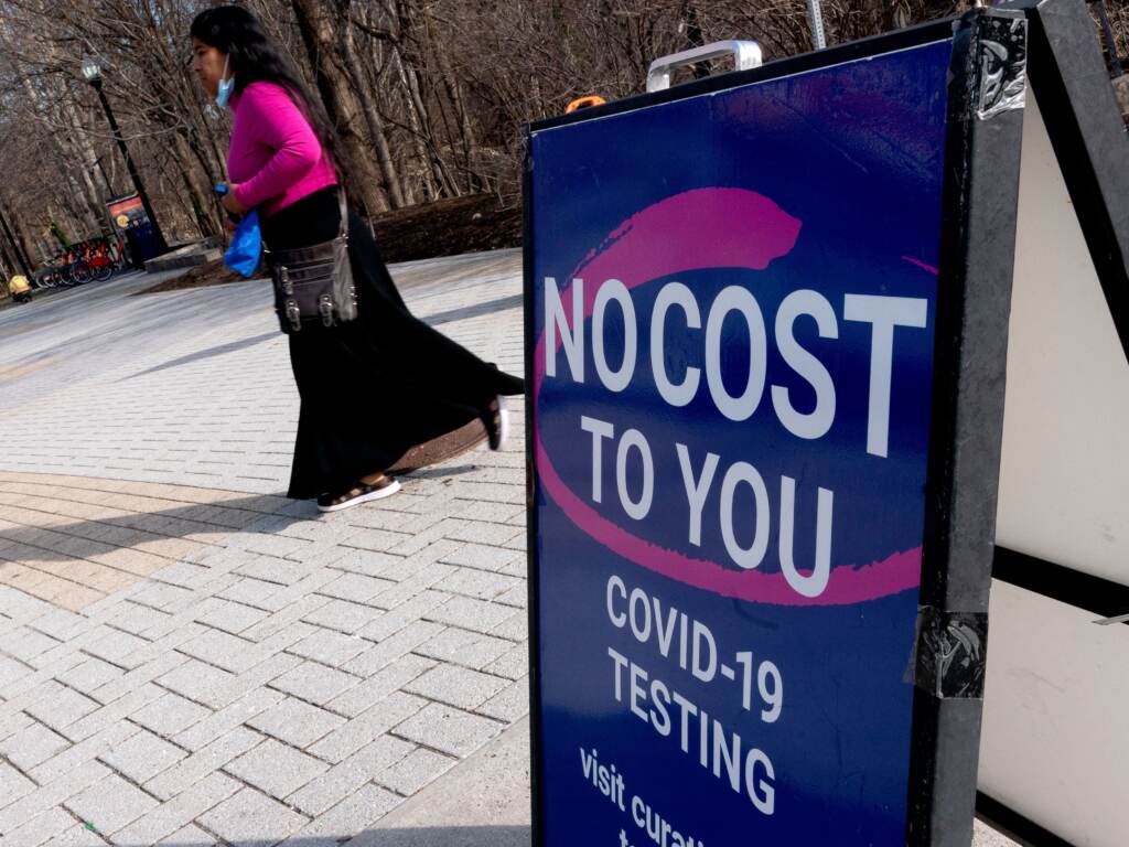 A person walks past a COVID-19 testing location in Arlington, Va., on March 16. A new website launched by the Biden administration will provide a locater for test-and-treat facilities, among other services. A person walks past a COVID-19 testing location
