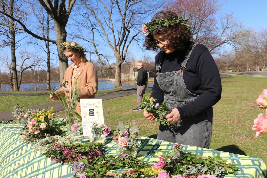 philly-flower-show-wreaths Jackie Small (left) and Miriam Singer of Philly DIY Wedding weave flower crowns during a preview of the Philadelphia Flower Show at FDR Park. (Emma Lee/WHYY)
