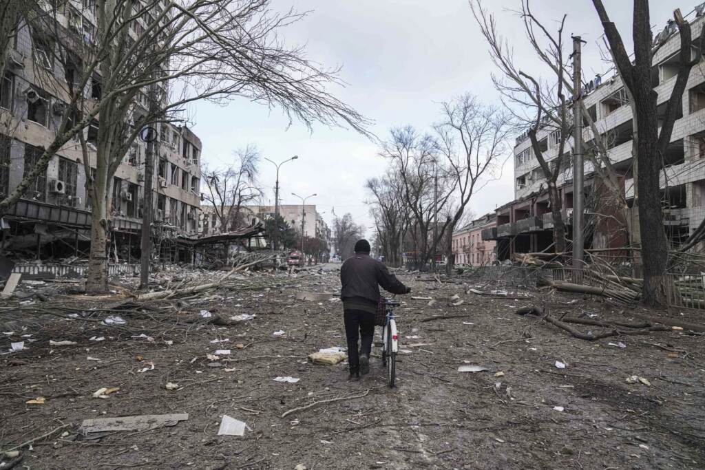 Russia Ukraine War Day In Photos A man walks with a bicycle in a street damaged by shelling in Mariupol