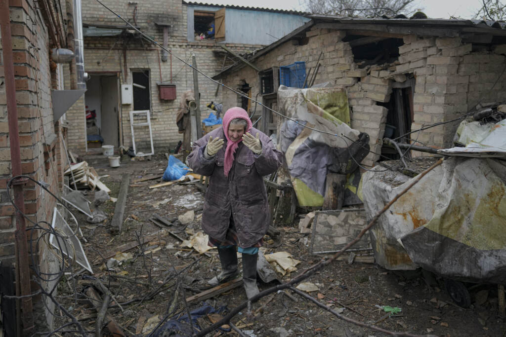 APTOPIX Russia Ukraine War A woman is overwhelmed by emotion in the backyard of a house damaged by a Russian airstrike