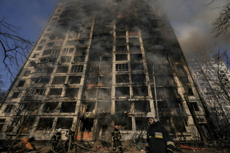 Firefighters work outside a destroyed apartment building after a bombing in a residential area in Kyiv