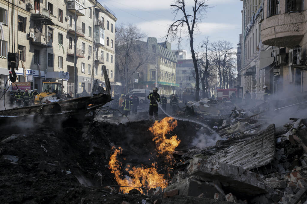 Firefighters extinguish flames outside an apartment house after a Russian rocket attack in Kharkiv,