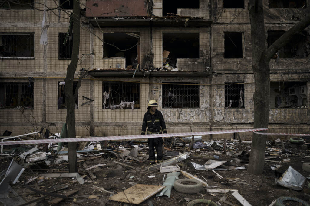 APTOPIX Russia Ukraine War A Ukrainian firefighter walks outside a destroyed building after it was hit by artillery shelling in Kyiv