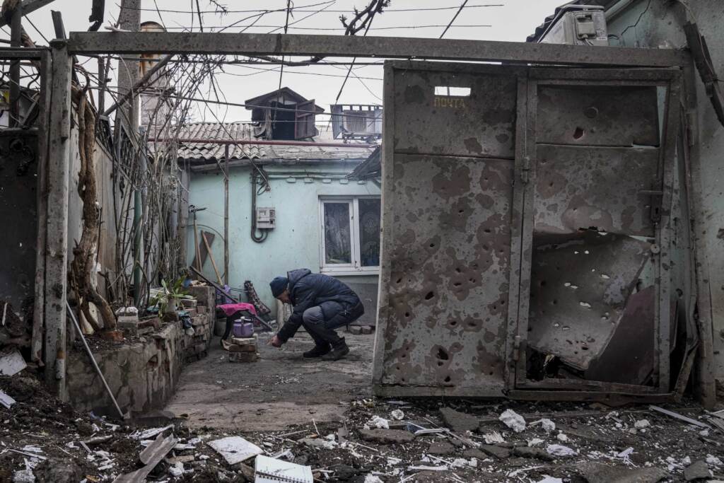 Russia Ukraine War A man lights a fire under the kettle in a yard of an apartment building hit by shelling