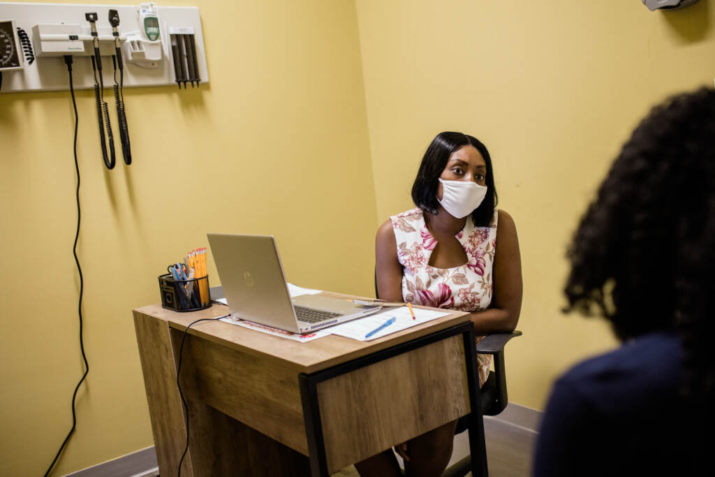 Margarette Osias, patient navigator for the Delaware Breast Cancer Coalition, speaks with one of her patients and assists her in scheduling a cancer screening. Osias is a bilingual Haitian Creole speaker, which helps her connect with the community she works with in Sussex County, Delaware. Margarette Osias speaks with one of her patients