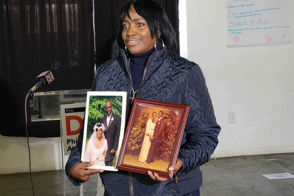 Keena Drinks, widow of Kevin Drinks, holds photos of the two of them from their wedding day.