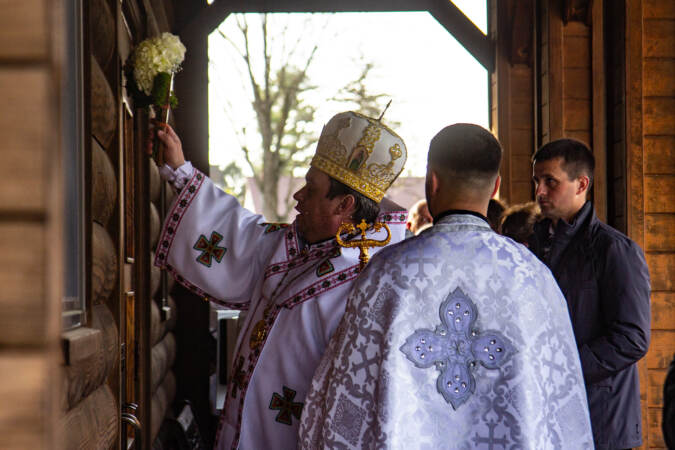 Bishop Andriy Rabiy makes the sign of the cross on the door of St. Michael the Archangel Ukrainian Catholic Church in Jenkintown, Pa., before Easter services on April 24, 2022.