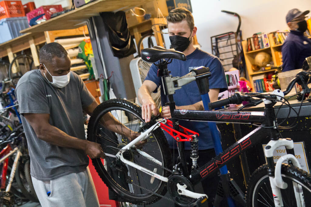 2022 04 28 k paynter bike church-5 Eric Holte (left) learns to fix his bike with volunteer Michael Benko