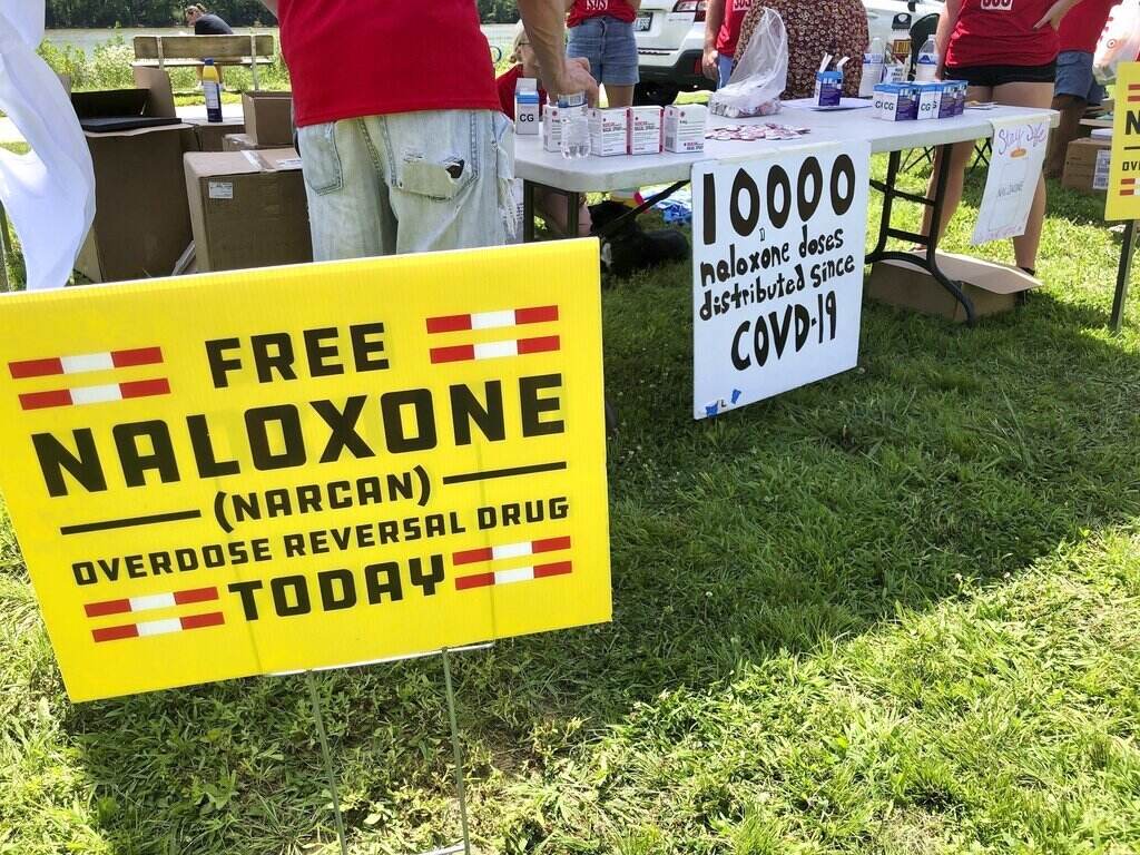 Opioid Crisis Fentanyl Signs advertise free Naloxone at a health event.