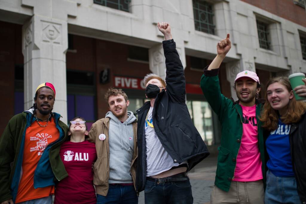 Amazon-Union-Elections People celebrate, raising their fists in the air.