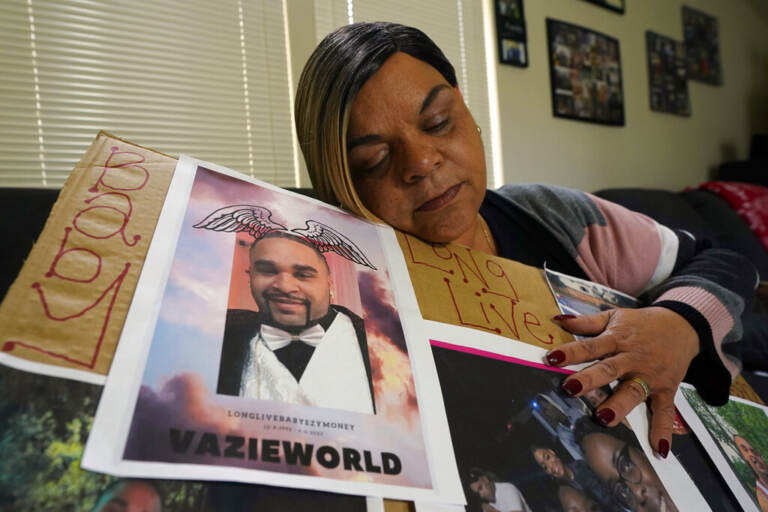Penelope Scott holds a collection of family photos including one of her son, De'vazia Turner, one of the victims killed in a mass shooting, during an interview with The Associate Press in Elk Grove, Calif., Monday, April 4, 2022. Multiple people were killed and injured in the shooting a day earlier.
