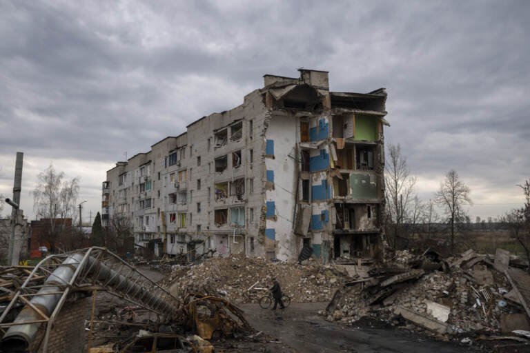 A man with a bicycle walks in front of a destroyed apartment building in the town of Borodyanka, Ukraine, on Saturday, April 9, 2022. Russian troops occupied the town of Borodyanka for weeks. Several apartment buildings were destroyed during fighting between the Russian troops and the Ukrainian forces in the town around 40 miles northwest of Kyiv.