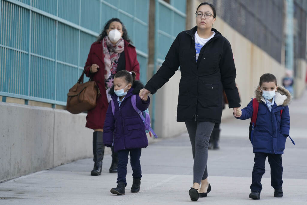 Virus Outbreak Travel FILE - Children and their caregivers arrive for school in New York, Monday, March 7, 2022. The Biden administration will extend for two weeks the nationwide mask requirement for public transit as it monitors an uptick in COVID-19 cases. The Centers for Disease Control and Prevention was set to extend the order, which was to expire on April 18, by two weeks to monitor for any observable increase in severe virus outcomes as cases rise in parts of the country. (AP Photo/Seth Wenig, File)