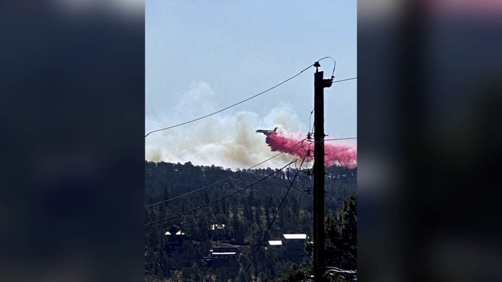 Western Wildfires This photo provided by the Village of Ruidoso shows a fire fighting air tanker dropping fire retardant across the mountains near the Village of Ruidoso, N.M., on Wednesday, April 13, 2022. (Kerry Gladden/Village of Ruidoso via AP)