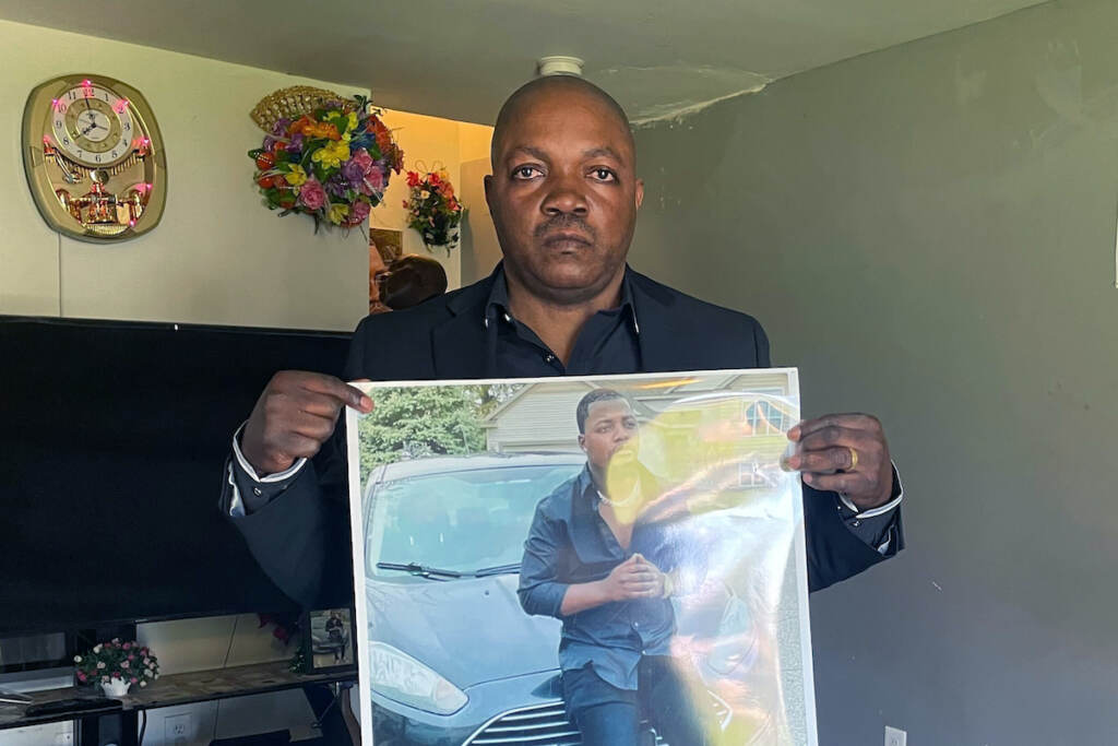 Police Shooting Michigan Peter Lyoya holds up a picture of his son Patrick Lyoya, 26, in his home in Lansing, Mich., April 14, 2022. Patrick was face-down on the ground when he was fatally shot in the head by a Grand Rapids Police officer after resisting arrest on April 4, 2022. Grand Rapids police released four videos from different sources Wednesday, nine days after Patrick Lyoya was killed during a traffic stop. Prominent civil rights attorney Ben Crump and Lyoya's family are planning to hold a news conference Thursday afternoon