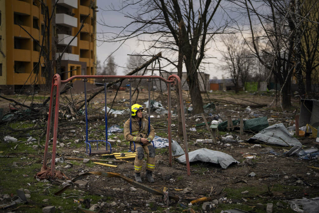 APTOPIX Russia Ukraine War A firefighter sits on a swing next to a building destroyed by a Russian bomb in Chernihiv on Friday, April 22, 2022. (AP Photo/Emilio Morenatti)
