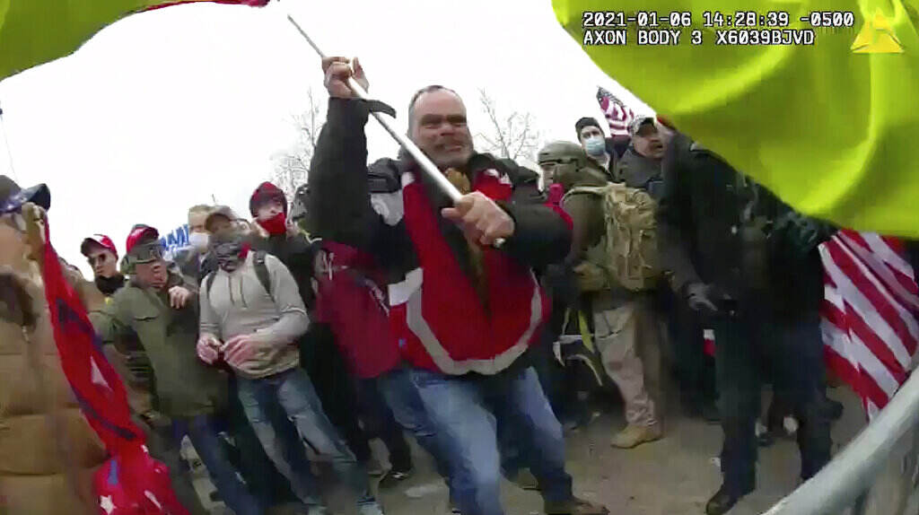 Capitol Riot Trials This still frame from Metropolitan Police Department body worn camera video shows Thomas Webster, in red jacket, at a barricade line at on the west front of the U.S. Capitol on Jan. 6, 2021, in Washington.