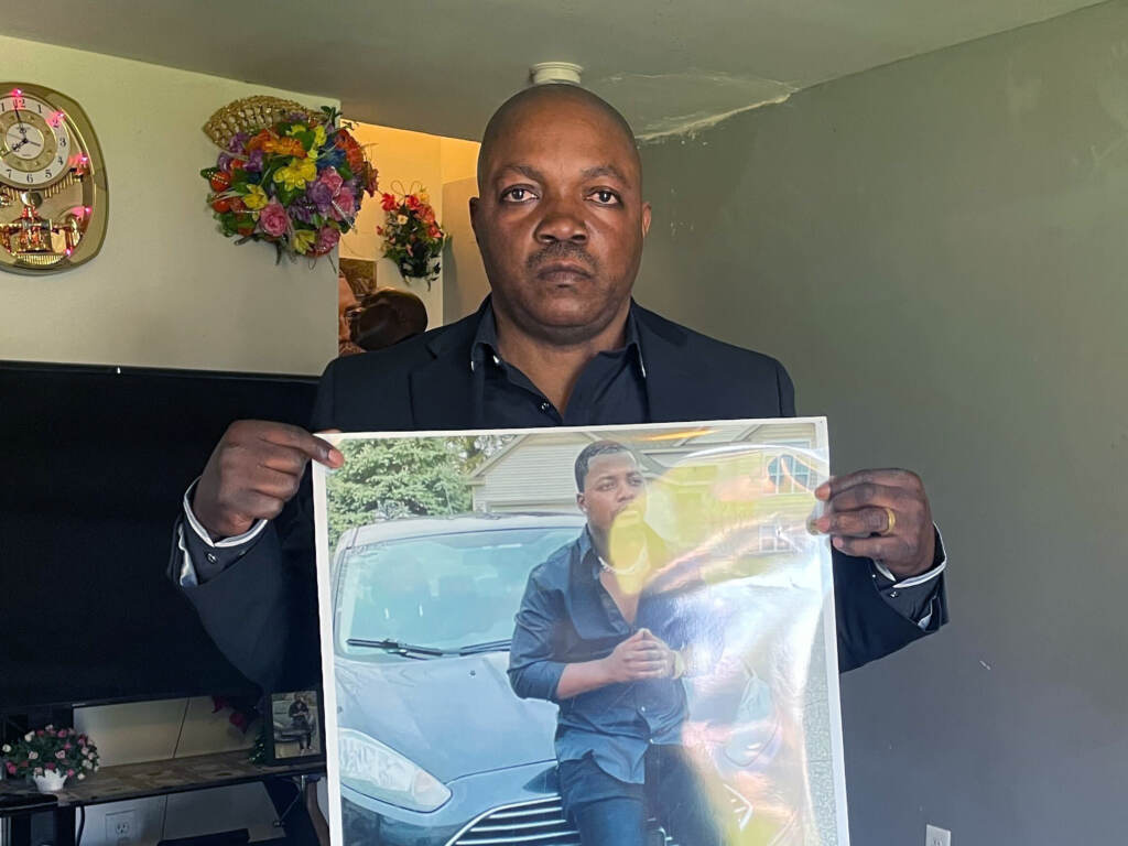 Peter Lyoya holds up a picture of his son Patrick Lyoya, 26, in his home in Lansing, Mich., on April 14. Patrick was facedown on the ground when he was fatally shot in the head by a Grand Rapids police officer this month. Peter Lyoya holds up a picture of his son Patrick Lyoya, 26, in his home in Lansing, Mich., on April 14. Patrick was facedown on the ground when he was fatally shot in the head by a Grand Rapids police officer this month.