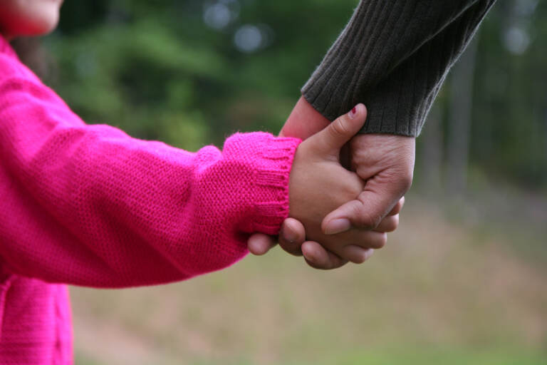 Mother and daughter holding hands