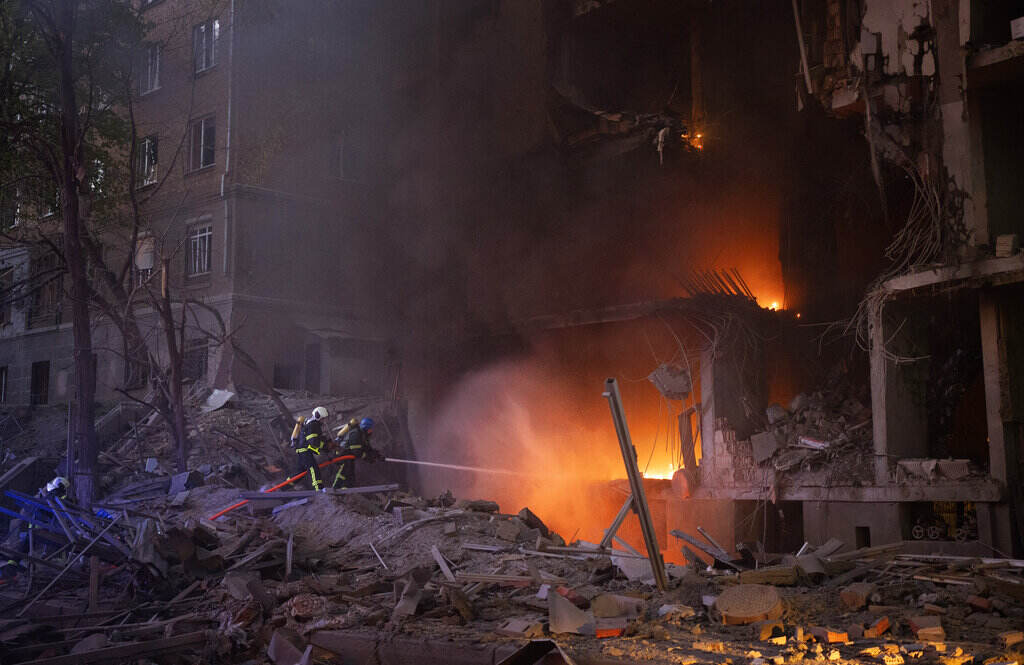 APTOPIX Russia Ukraine War Bright flames are visible in a building that is partially destroyed.