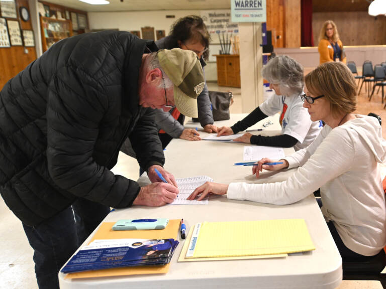 File photo: Caucus goers sign in on February 3, 2020 in Carpenter, Iowa. Iowa is the first contest in the 2020 presidential nominating process with the candidates then moving on to New Hampshire. (Steve Pope/Getty Images via NPR)
