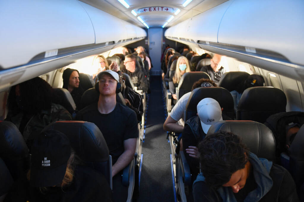 Airline passengers, some not wearing face masks following the end of the federal mask mandate, sit during a American Airlines flight operated by SkyWest Airlines from Los Angeles International Airport to Denver, on Tuesday. Airplane passengers, some not wearing face masks