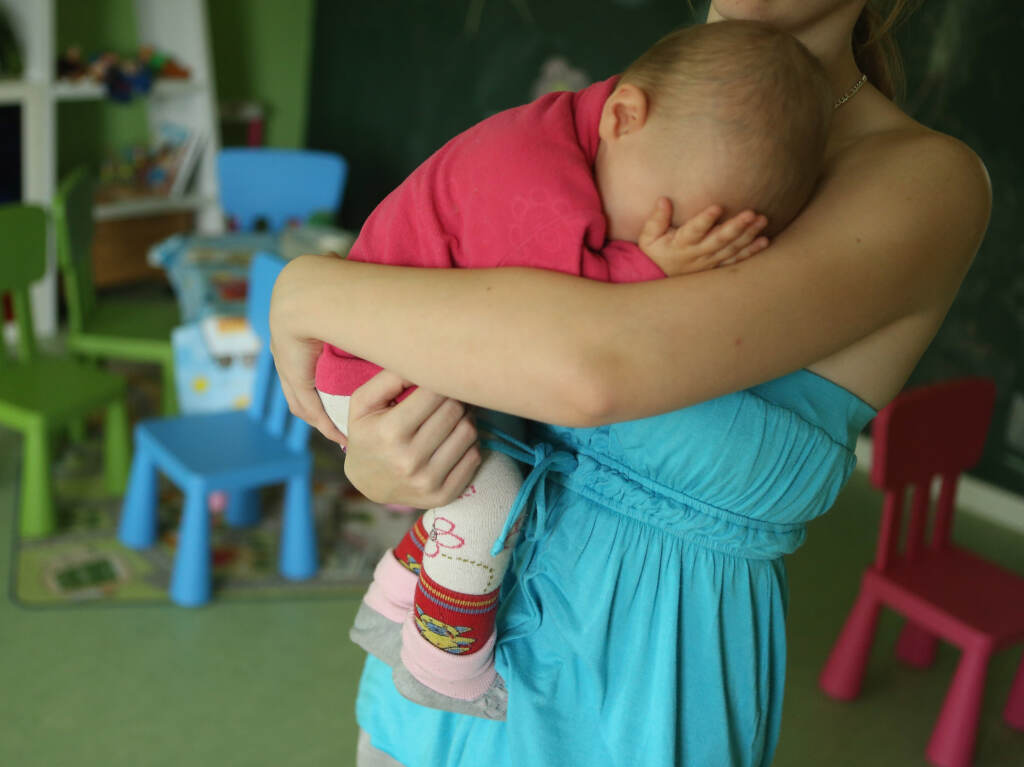 A baby sleeps in her mother's arms.