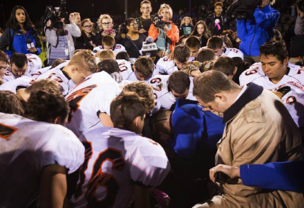 The parties included this image, of Coach Kennedy praying with a crowd after the homecoming game, in their joint appendix submitted to the Supreme Court The parties included this image, of Coach Kennedy praying with a crowd after the homecoming game, in their joint appendix submitted to the Supreme Court
(Court Filings)