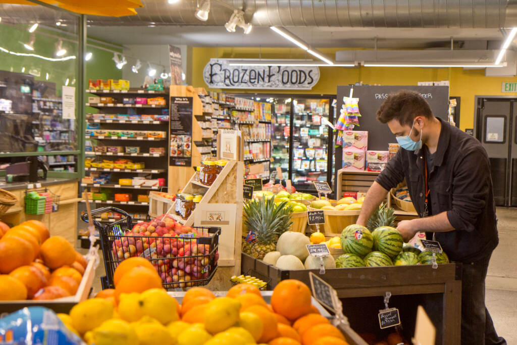 Fresh produce at the Kensington Community Food Co-op. (Kimberly Paynter/WHYY) A member-worker arranges produce at the Kensington Community Food Co-op